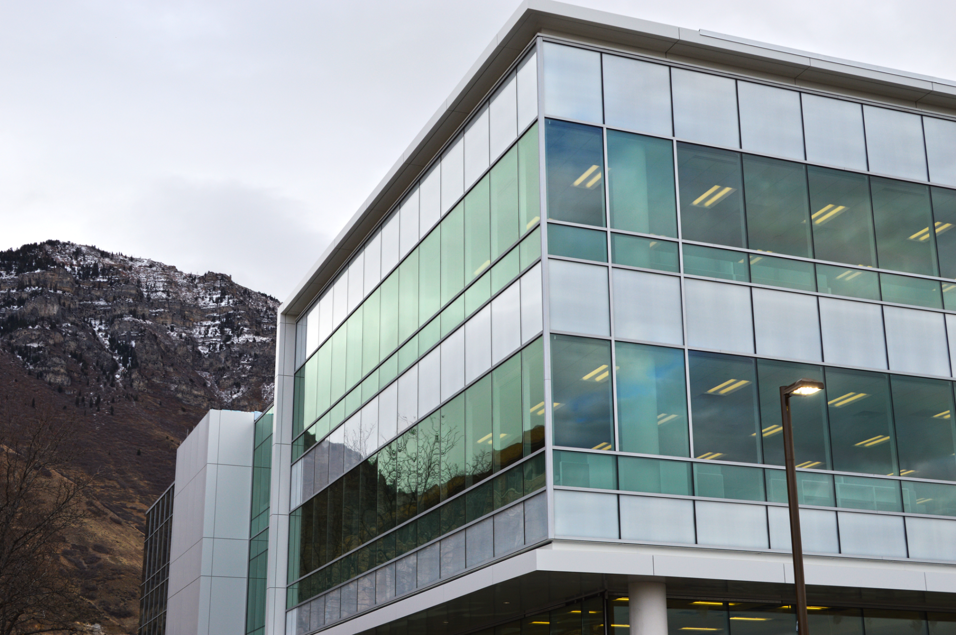 A building with many large windows and a mountain behind it